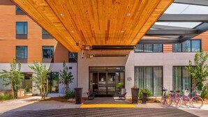 A modern building entrance with a wooden ceiling, potted plants, and bicycles parked outside. - Hampton Inn and Suites South Lake Tahoe (South Lake Tahoe)
