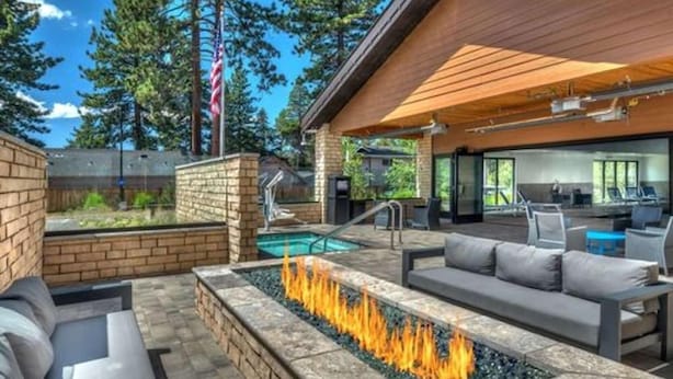 An outdoor patio with a fire feature, seating, and a pool. - Hampton Inn and Suites South Lake Tahoe (South Lake Tahoe)