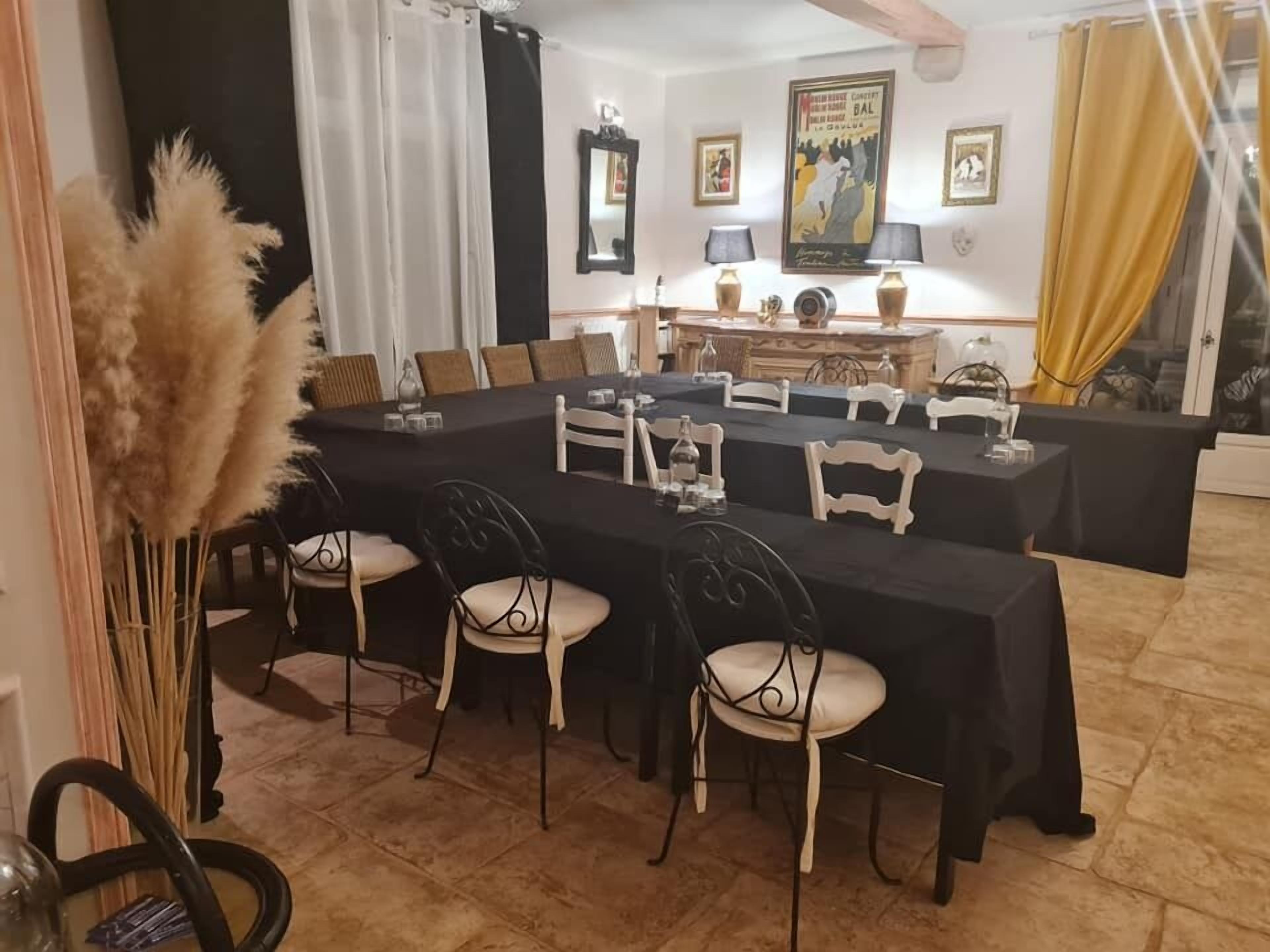 A dining area with a long table set for a meal, surrounded by chairs.