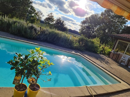 Una piscina al aire libre de temporada, sombrillas