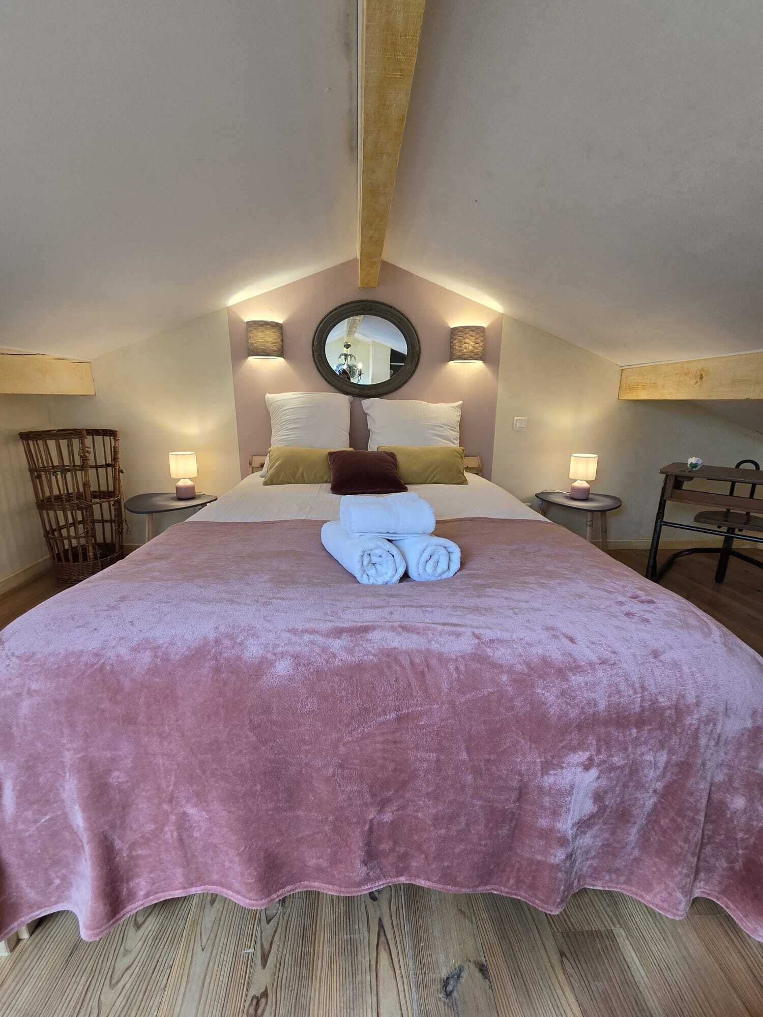 Une chambre à coucher avec un grand lit, un plafond en bois et deux lampes de chevet.
