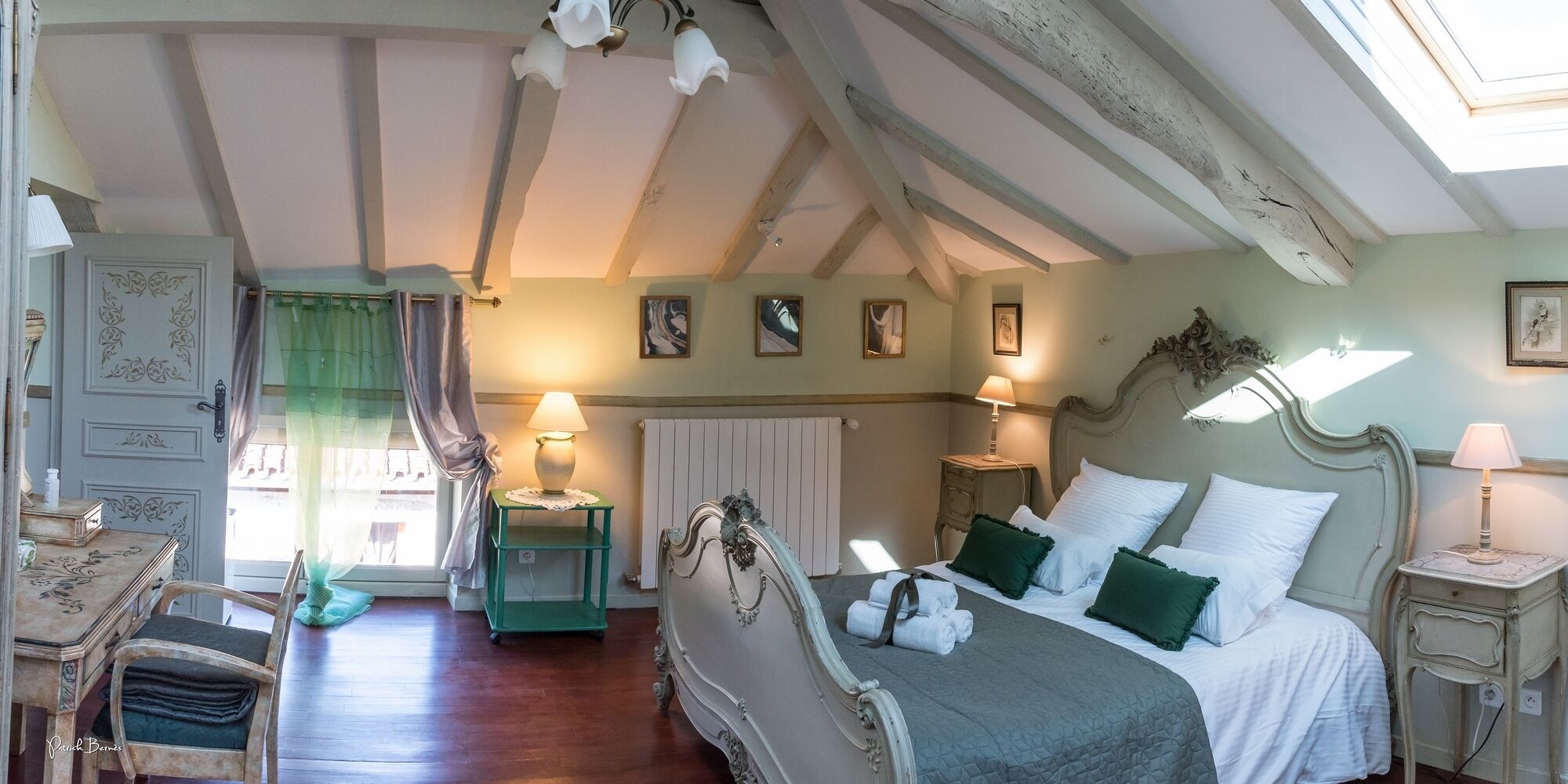 Een slaapkamer met een bed, twee nachtkastjes, een stoel, een radiator en een raam met gordijnen.