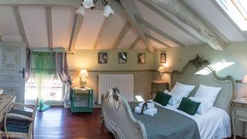 Een slaapkamer met een bed, twee nachtkastjes, een stoel, een radiator en een raam met gordijnen.