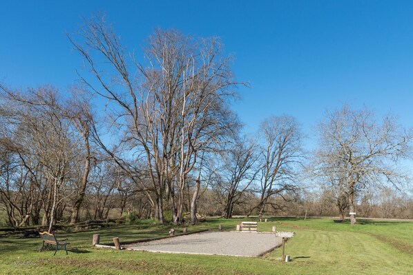 Ein Park mit Kieswegen, Bänken und Bäumen.