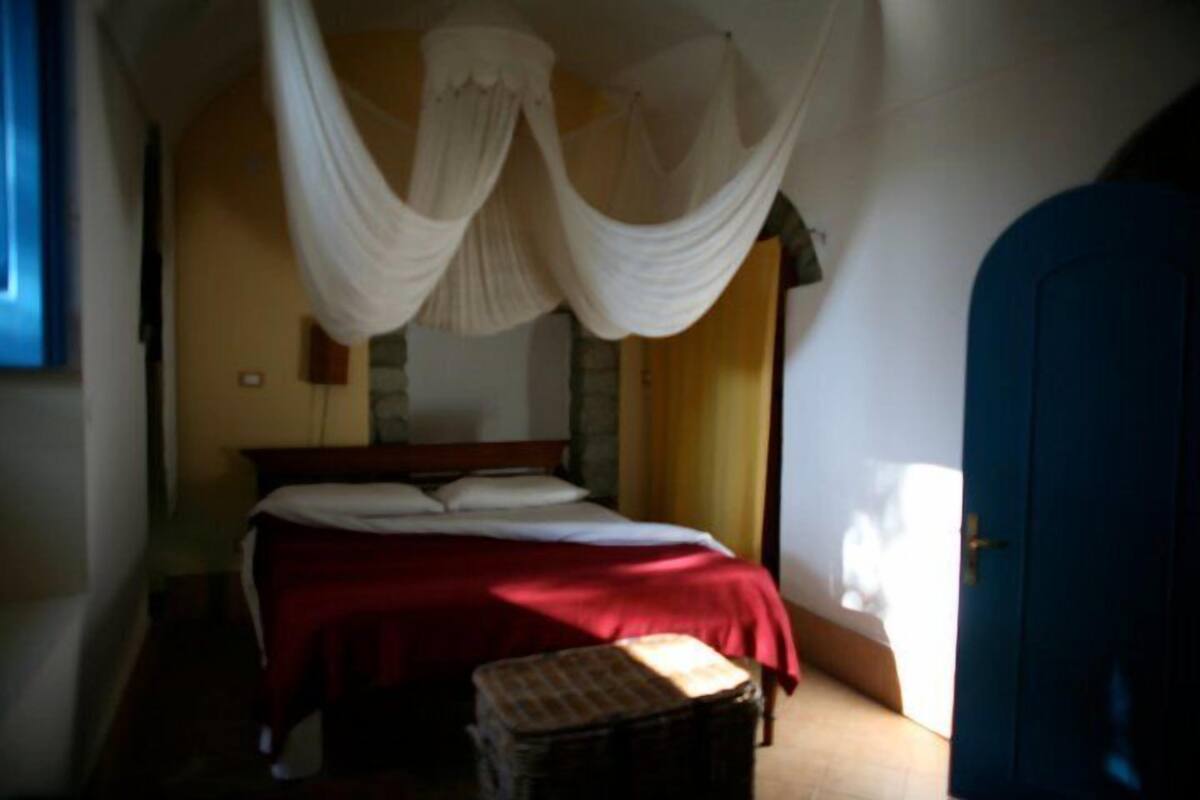 Un dormitorio con una cama, una mesita de noche, una silla y una puerta azul.