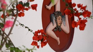 A decorative sculpture of a reclining figure with a blurred face, surrounded by red flowers. - Dimora Coloniale B&B (Forio)