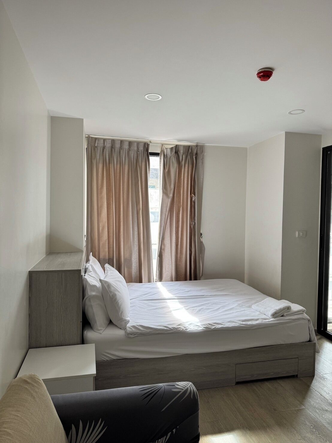 A compact bedroom with a bed, bedside tables, and a wardrobe.