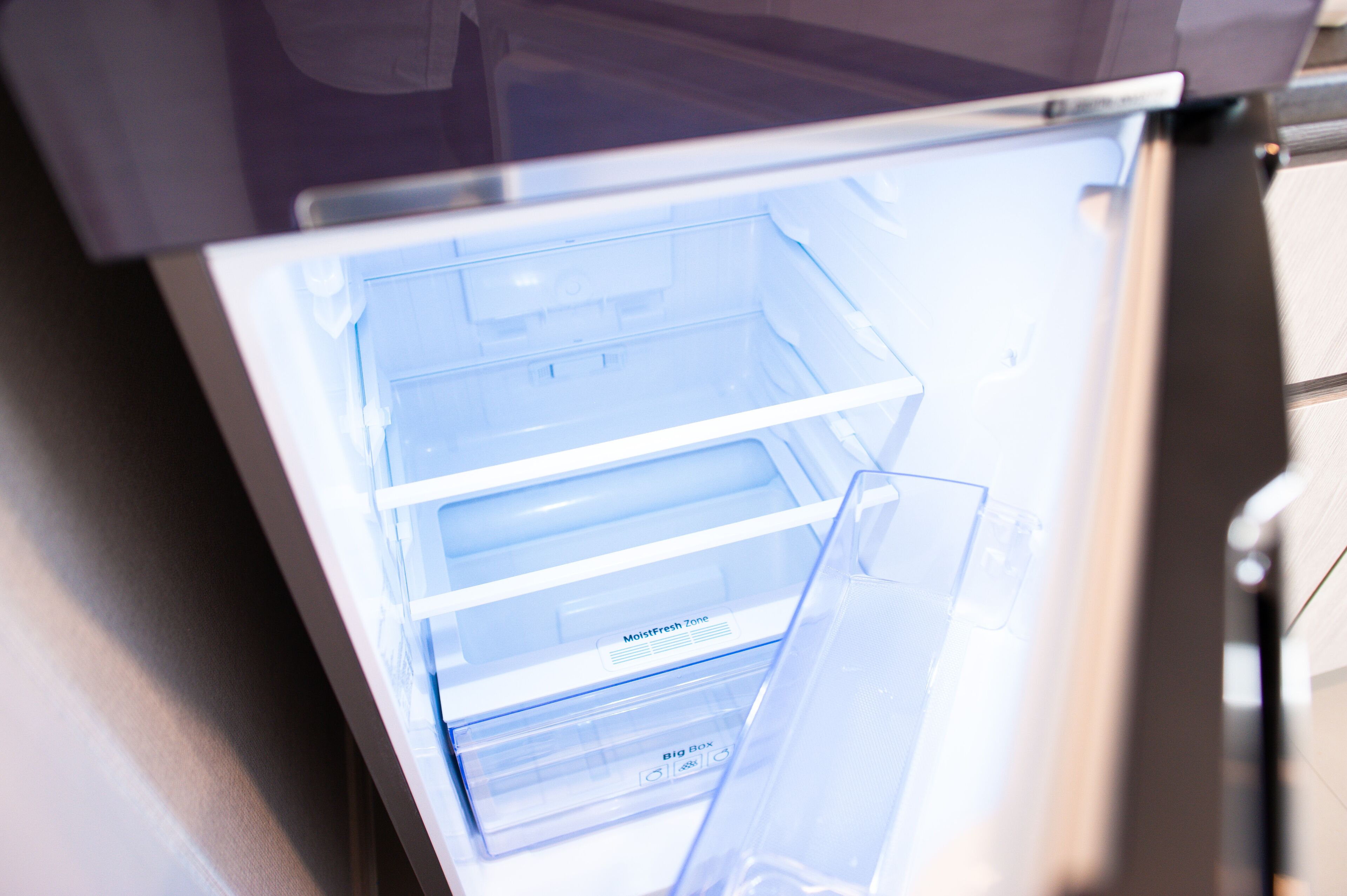 An open refrigerator with multiple compartments, including a 'MoistFresh Zone' and a 'Big Box' section.