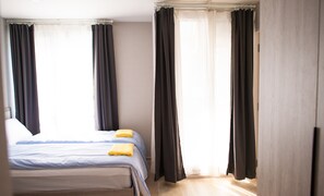 A hotel room with a bed, two pillows, and a yellow towel. - I'm Chinatown Residence (Bangkok)