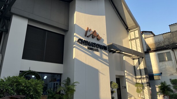 A modern building with a curved facade, a large window, and a sign that reads "CHINATOWN RESIDENCE". - I'm Chinatown Residence (Bangkok)