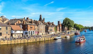 Explore the charming riverside town, where boats and a pedestrian walkway invite relaxation and discovery.