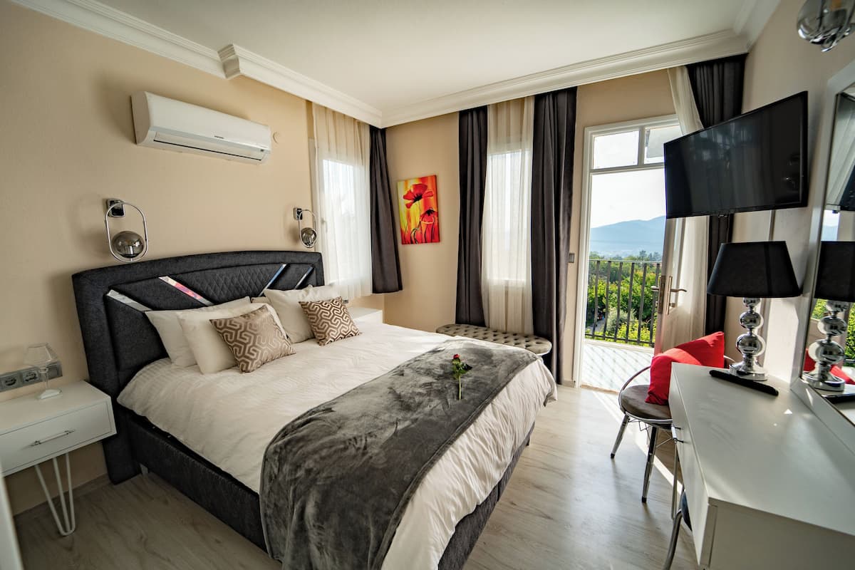 Una habitación de hotel moderna con una cama grande, un escritorio y un televisor.