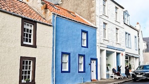 A narrow street with buildings painted in white and blue. - Oyster Cottage- relaxing retreat by the sea (Saint Monans)