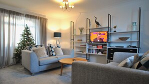 A living room with a sofa, coffee table, and a television. - Mariners Retreat- spacious apartment in Crail (Crail)