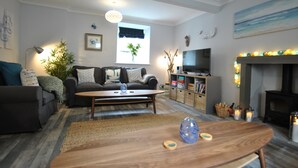 A modern living room with a sofa, coffee table, and fireplace.