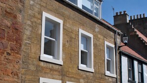 A two-story building with a brick facade and white-framed windows. - Coastal Rest-  superb East Neuk townhouse (Anstruther)