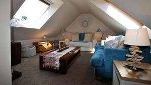 A cozy loft bedroom with a sloped ceiling, a heart-shaped wall decoration, and a skylight. - Turnstone- beautiful coastal home, Pittenweem (Pittenweem)