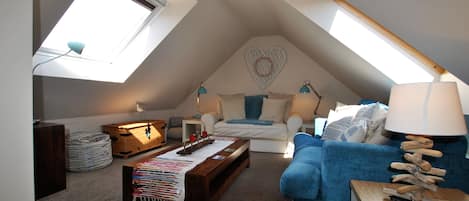 Une chambre à coucher chaleureuse, aménagée en mezzanine, avec un plafond en pente, une décoration murale en forme de cœur et un puits de lumière.
