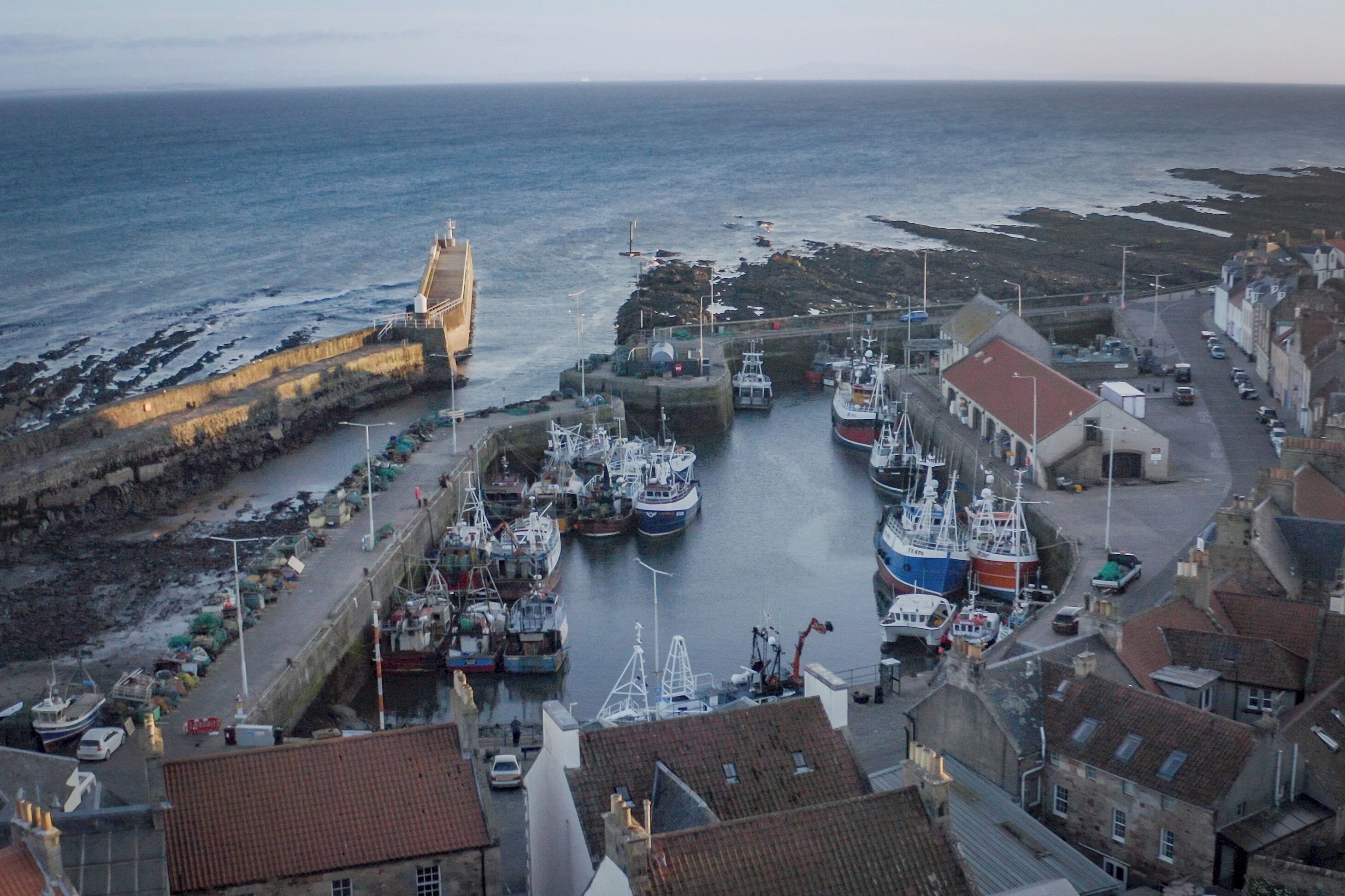 A coastal town with a harbor, boats, and buildings.