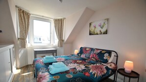 A bedroom with a bed, a desk, a window, and a painting on the wall. - The Beacon-  coastal home in St Monans (Saint Monans)