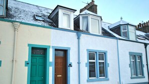 A two-story building with a green door and a brown door, both with numbers above them. - The Beacon-  coastal home in St Monans (Saint Monans)