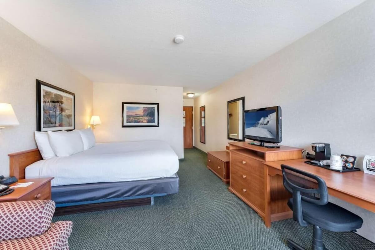 Une chambre d’hôtel équipée d’un lit, d’un bureau, d’une chaise et d’un téléviseur.