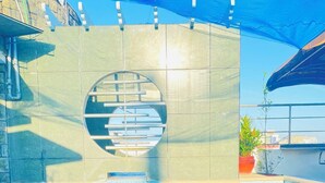 Una piscina amb una finestra circular, parets revestides i una teulada blava a la part superior.
