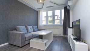 Apartamento família | Área de estar | TV de tela plana
