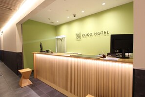 A reception desk with a modern design, a security camera, and a sign for KOKO HOTEL. - Koko Hotel Osaka Namba (Osaka)