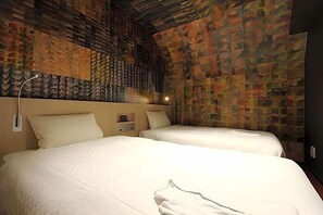 Une chambre d’hôtel avec deux lits, un mur orné de motifs et un plafond au design original.