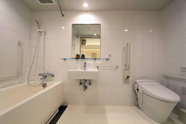 Ein modernes Badezimmer mit einer Badewanne, einem Waschbecken, einer Toilette und einem Spiegel über dem Waschbecken.