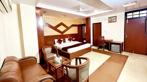 Una habitación de hotel con cama, escritorio, silla, sofá y armario.