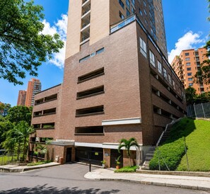 A multi-story parking garage with a brick facade, multiple levels of parking, and a gated entrance.