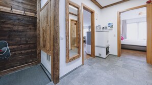 A modern hotel room with a wooden accent wall, a large mirror, and a bed with a view. - Chalet Badia by we rent (Zell am See)