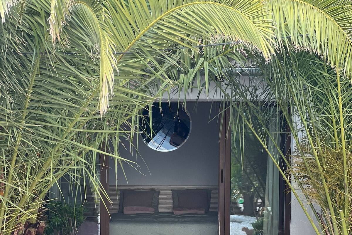 A pathway leading to a modern building with a glass door and a circular window.