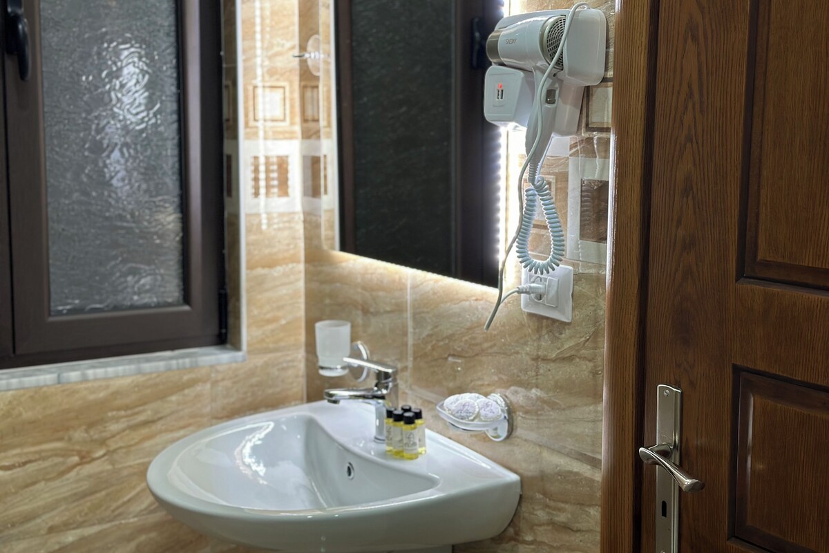 Un baño con lavamanos, secador de pelo y espejo.
