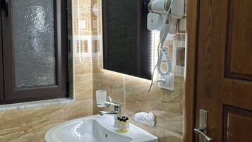 Un baño con lavamanos, secador de pelo y espejo.