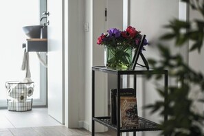 Ein modernes Interieur mit einem schwarzen Metallregal, das eine Blumenvase und ein Buch mit dem Titel 'Dancing on my Grave' von Gehlen Kirkland beherbergt.