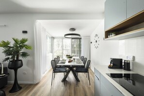 Una cuina moderna amb taulell negre, forn de mur i microones.