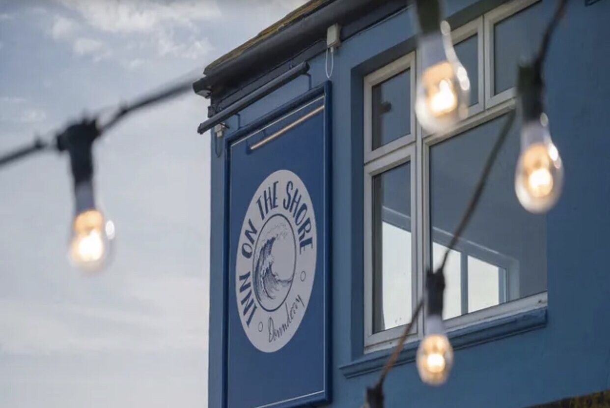 Ein Gebäude mit einem Schild, auf dem ‚The Shore Inn‘ steht.