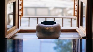 A large, textured vase on a reflective surface near a window with wooden frames. - Secret Orange by DuHomes (Dubrovnik)