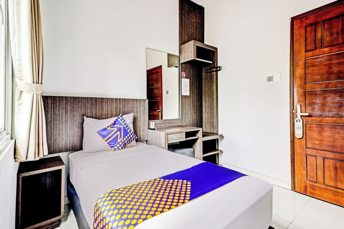A bedroom with a bed, a dresser, a mirror, and a wooden door.