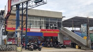 A building with a staircase leading to a covered area, a row of parked motorcycles, and a sign for a juice bar. - Hotel O Cihampelas Near Ciwalk Formerly D'River Guest House (Bandung)