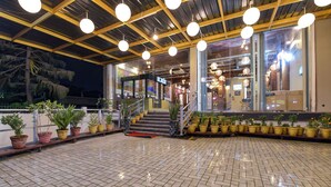 A well-lit entrance with tiled flooring, a staircase, and potted plants. - Fabhotel Prime Shubh ISBT (Dehradun)