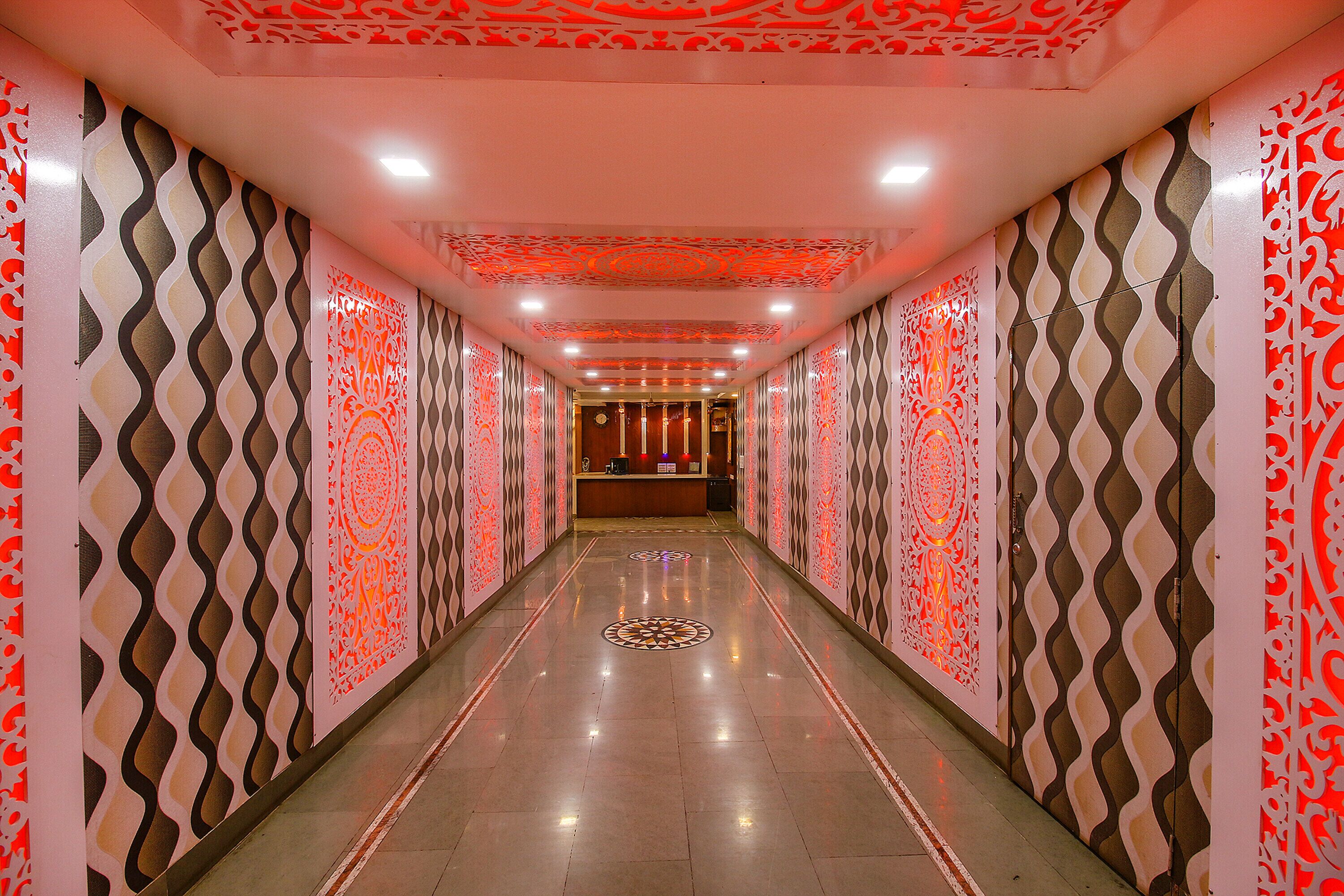 A corridor with patterned walls and a reception desk at the end.