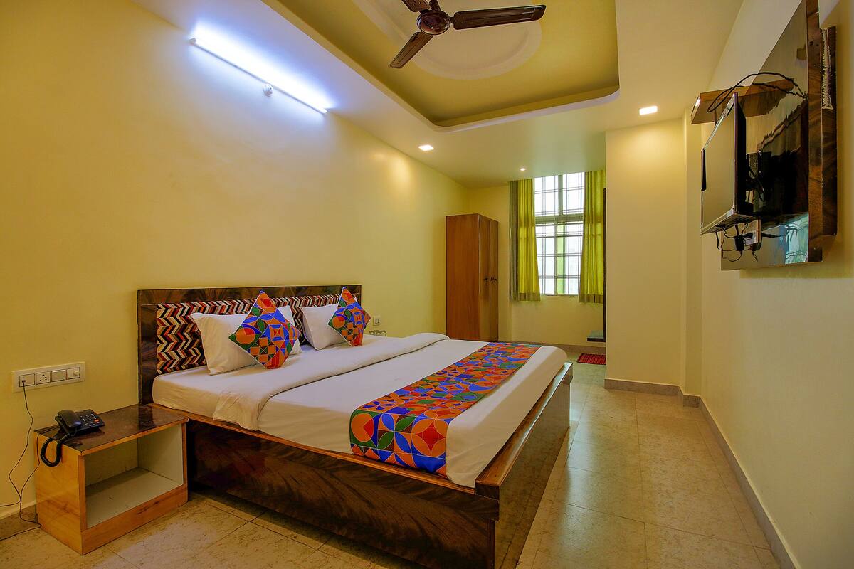 Quarto com cama, mesa de cabeceira e ventilador de teto.
