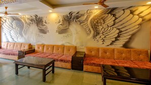 Une pièce avec une grande fresque murale représentant un cheval, un canapé et une table basse.