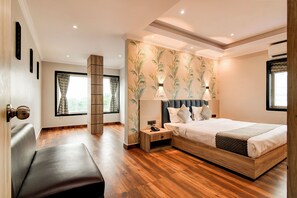 Un dormitorio moderno con una cama de madera, una mesita de noche, un banco y un ventanal con cortinas.