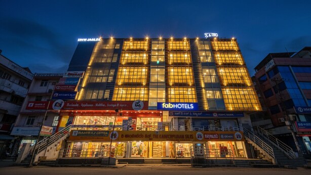 Un edificio de varios pisos con un letrero llamativo de 'fabHOTELS' al nivel de la calle.