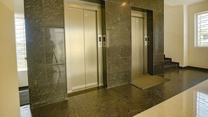 Un ascensor moderno con pared de mármol y suelo pulido e impecable.